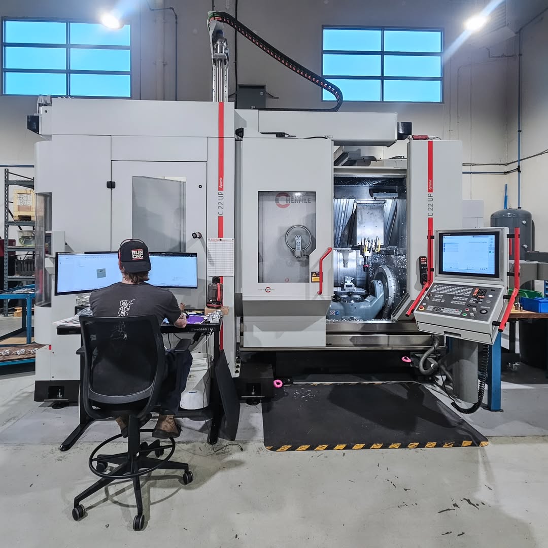Operator sitting at computer in front of Hermle C22 UP 5-Axis machine