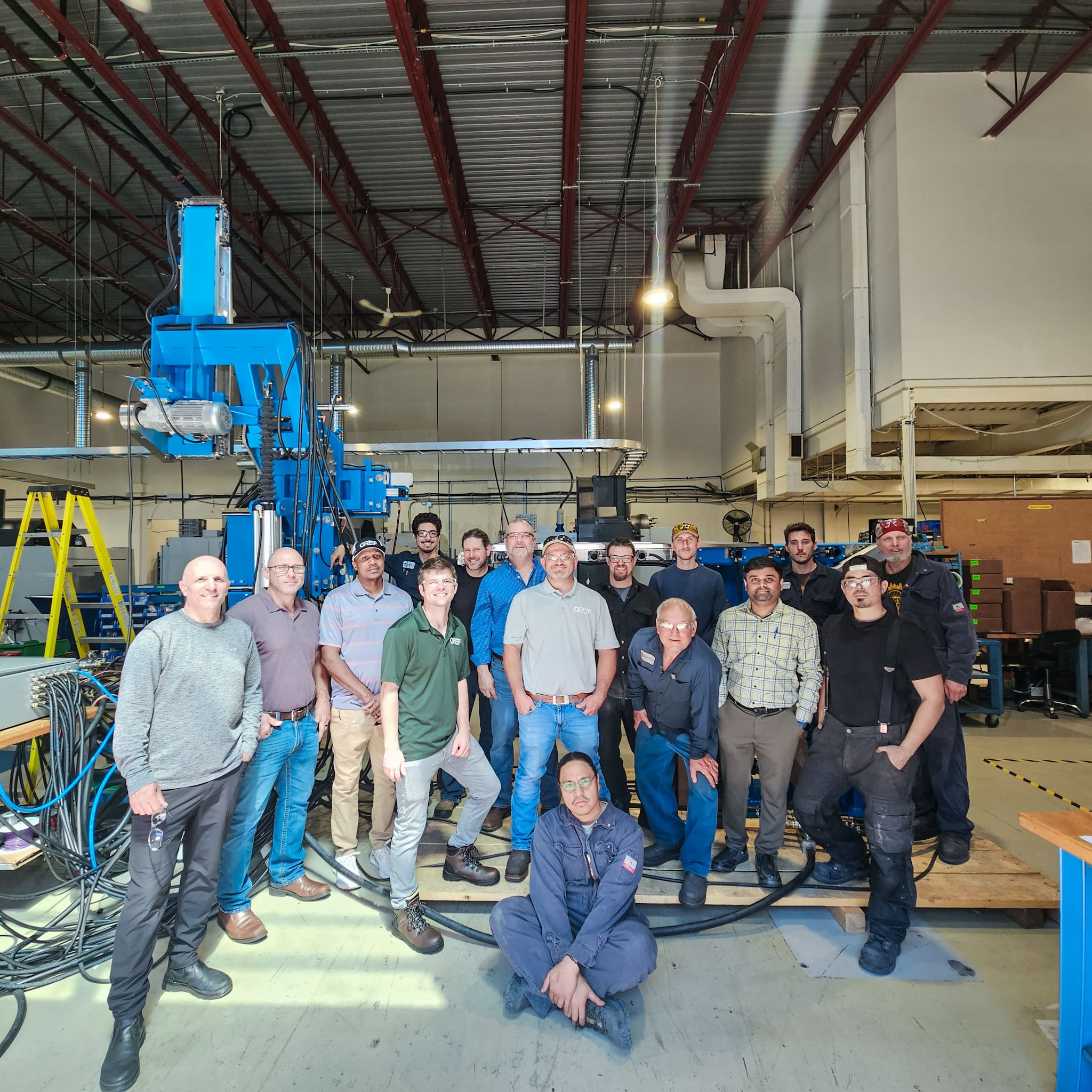 Group photo in front of automated tail threading system in Mantech shop